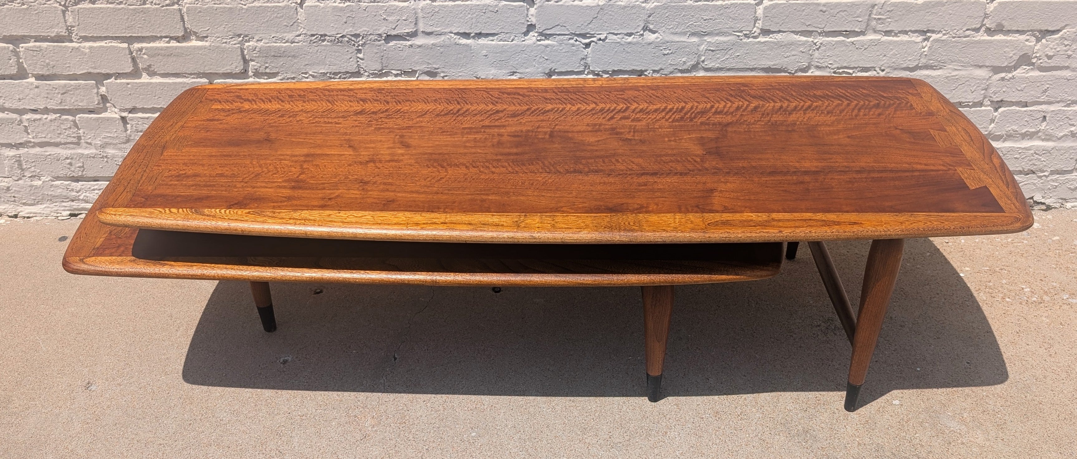 Wooden coffee table against a brick wall.