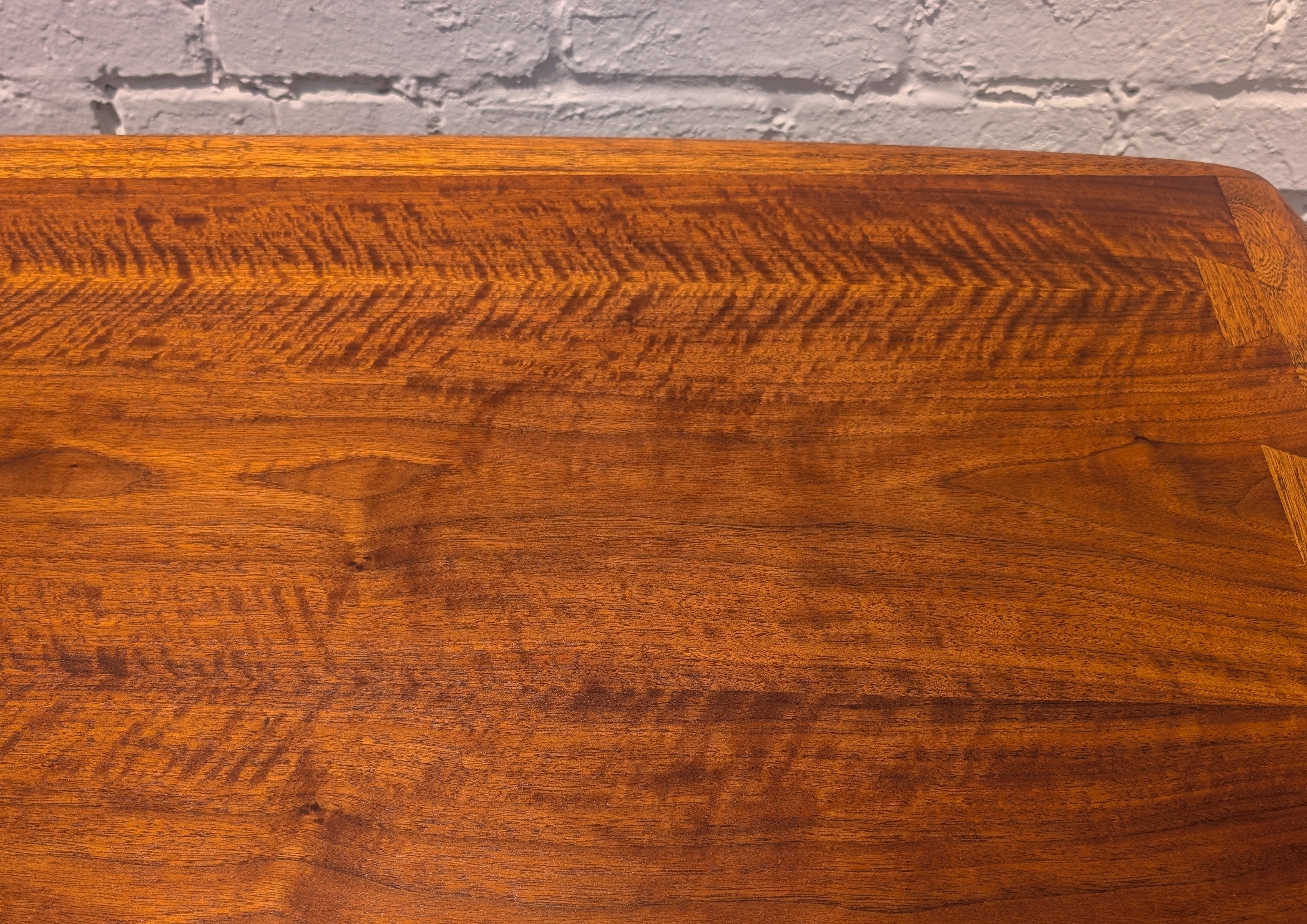 Close-up of a wooden surface with a gray brick wall background
