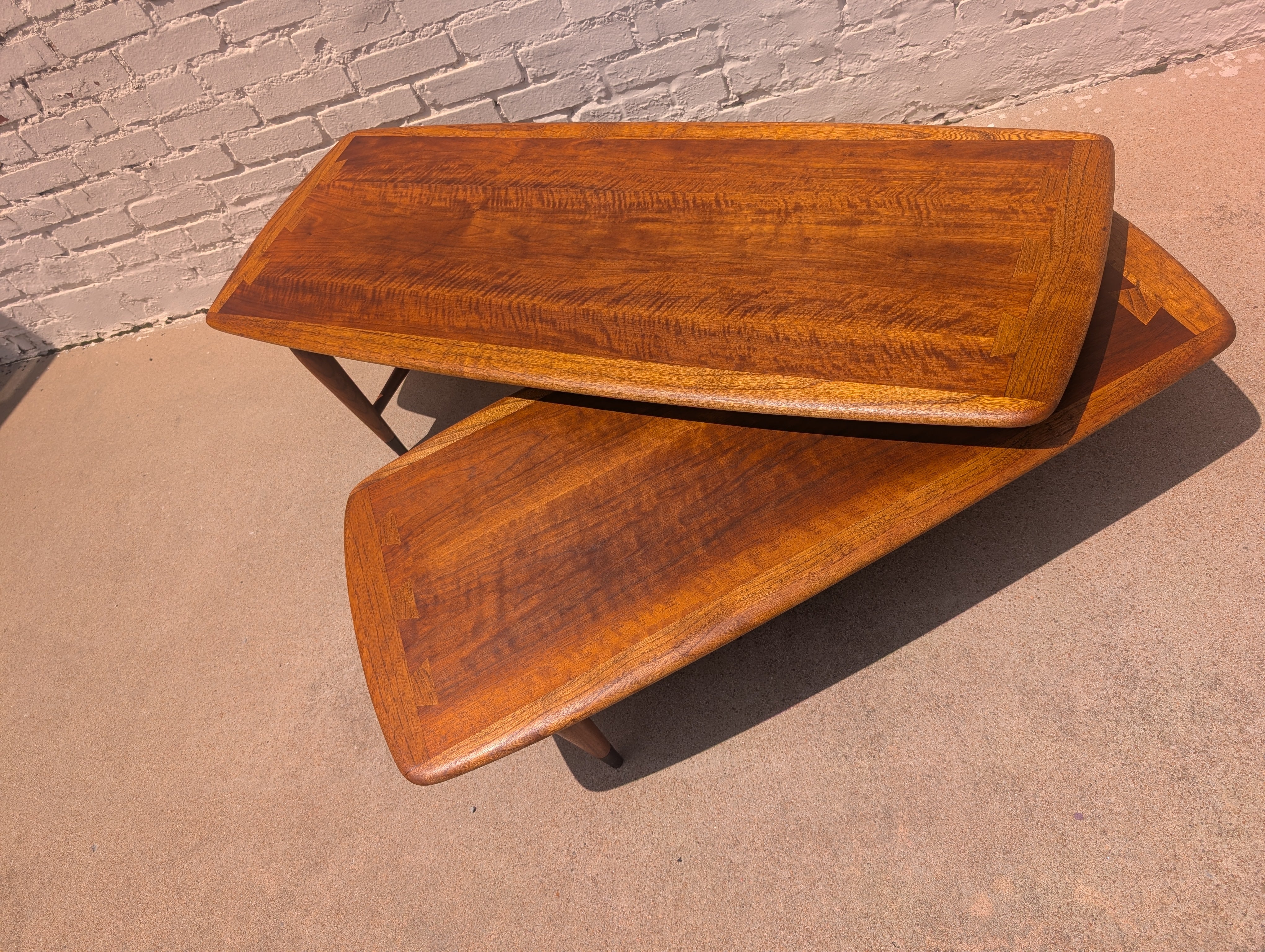 Wooden footstool with a textured surface on a concrete floor.
